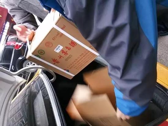 在仁怀市内的交易地点,售假者正为购买者开箱验货。