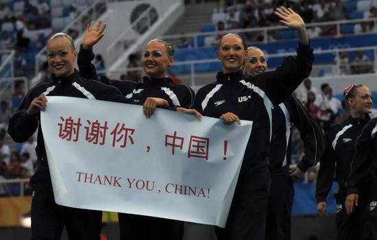 2008奥运花样游泳女子团体赛入场时,美国队打着“谢谢你,中国!”的标语向观众致意。图 / 视觉中国