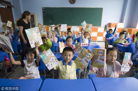 2017年9月1日,太原,小学生们翻看新版统编教材 @视觉中国