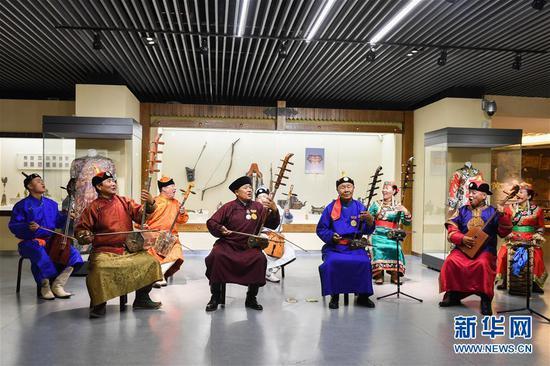 7月15日,在赤峰博物馆,《格萨(斯)尔》国家级非遗传承人金巴扎木苏(前排右二)和团队一起表演节目。新华社记者 刘磊 摄