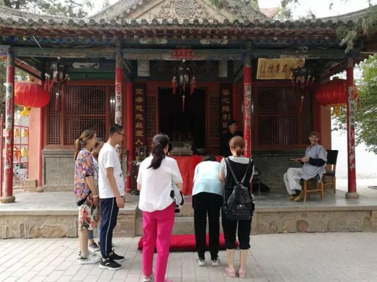 桃花山的寺庙里,考生家长陪孩子前来求保带。王双兴 摄
