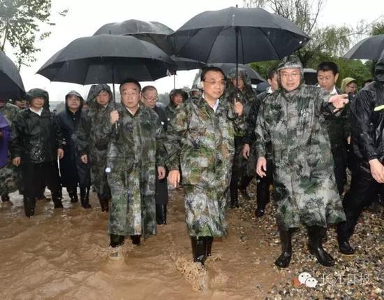 李克强总理趟水在青山倒口湖堤段管涌现场指挥抢险救灾。 长江日报记者周超 摄