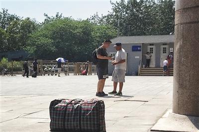 7月7日,北京西站,黄牛和乘客交易火车票。新京报记者 彭子洋 摄