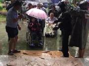 暴雨致养老院进水近300老人大转移 众人撑伞做接力雨棚