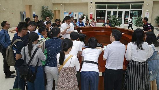 2018年5月19日,天津,滨海新区行政审批中心服务大厅,引进人才联审窗口为外省市人才办理落户新区业务的工作人员一刻未停。图片来源:视觉中国