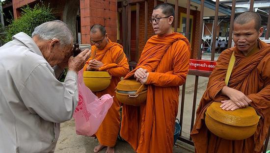 7月9日,泰国清莱,民众向僧侣们祈祷,为泰国山洞被困少年祈福。图片来源:视觉中国