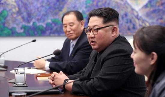 朝鲜最高领导人金正恩身穿富有朝鲜特色的黑色“人民装”,戴着一副富有时尚气息的豹纹眼镜。