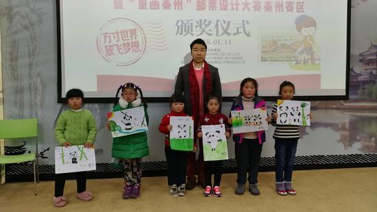 刘中现场为孩子们点评作品并签字留念
