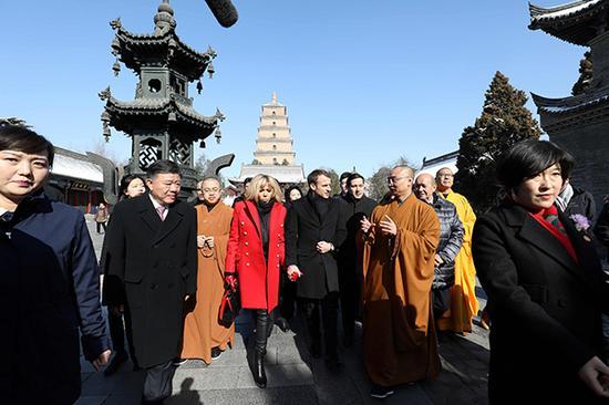 马克龙在参观大雁塔时,聆听寺院僧人做讲解。