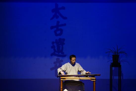 年轻的古琴艺术家在演奏琴曲
