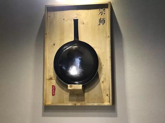 济南宽厚里某铁锅体验店里,王玉海打制的锅被叫做“宗师”系列锅,挂在墙上第一次序位置展示。