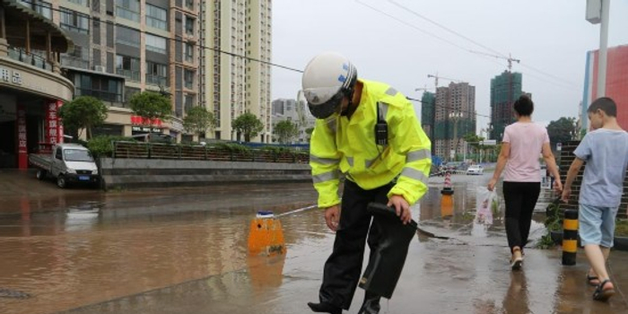 暴雨致巴中城区路面积水 交警水中执勤充当警示标志
