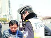 女车主为避交警处罚脱衣打滚