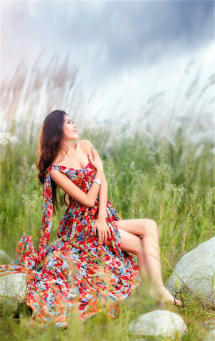 空旷户外里一个长发飘飘的美丽花裙美女