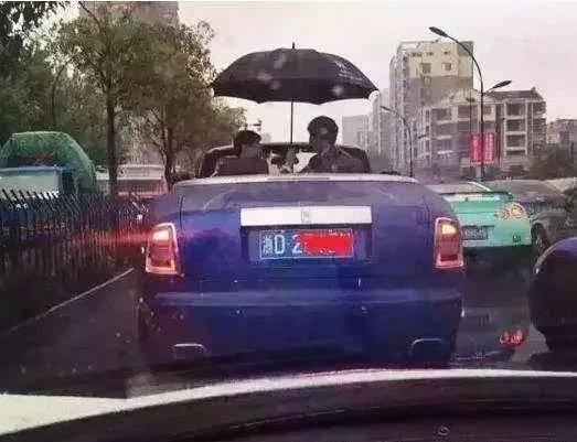 土豪开车另类的炫富方式——一手抓方向盘一手撑伞，路人喜闻乐见