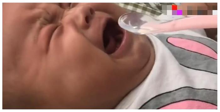 小宝宝在哭闹，妈妈拿勺子放进宝宝的嘴里，宝宝瞬间停止哭泣