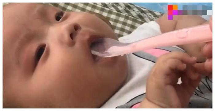 小宝宝在哭闹，妈妈拿勺子放进宝宝的嘴里，宝宝瞬间停止哭泣