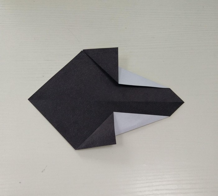 第五步:两侧沿边折角。 第六步:沿中心线折。 第七步:翻转纸张,从下往上折