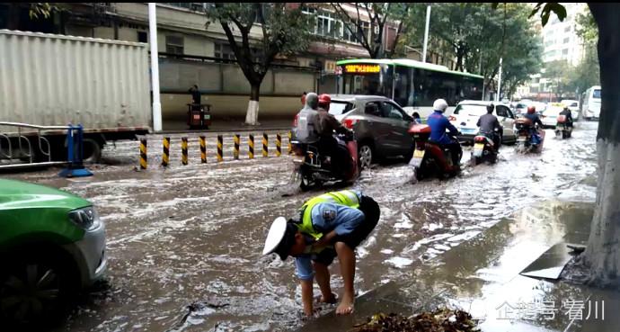 暴雨致城市内涝交通拥堵，交警赤脚跪地徒手掏下水道垃圾