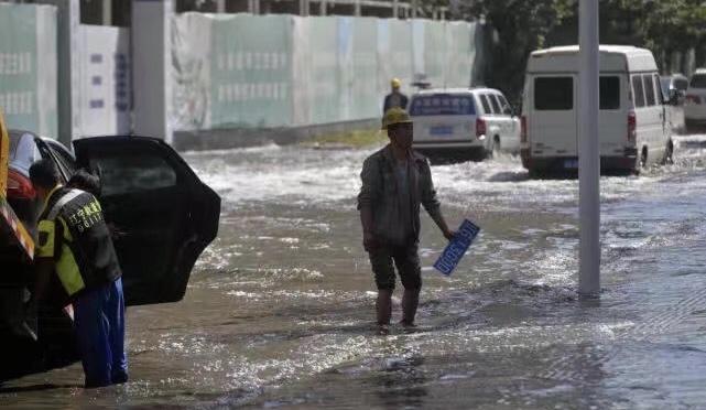 暴雨后农民工污水中摸车牌：谁丢的车牌谁拿走，我们不收钱