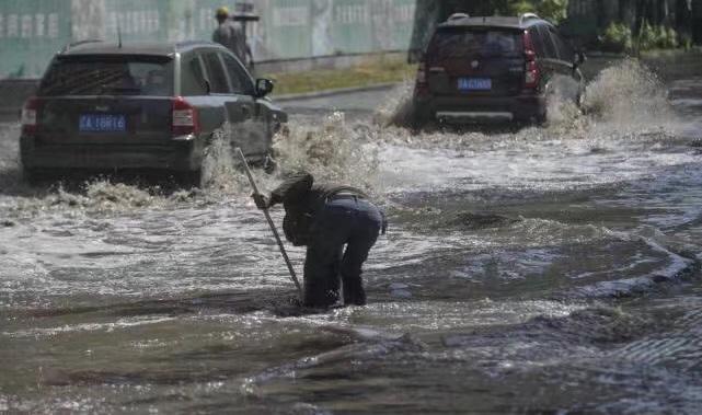 暴雨后农民工污水中摸车牌：谁丢的车牌谁拿走，我们不收钱