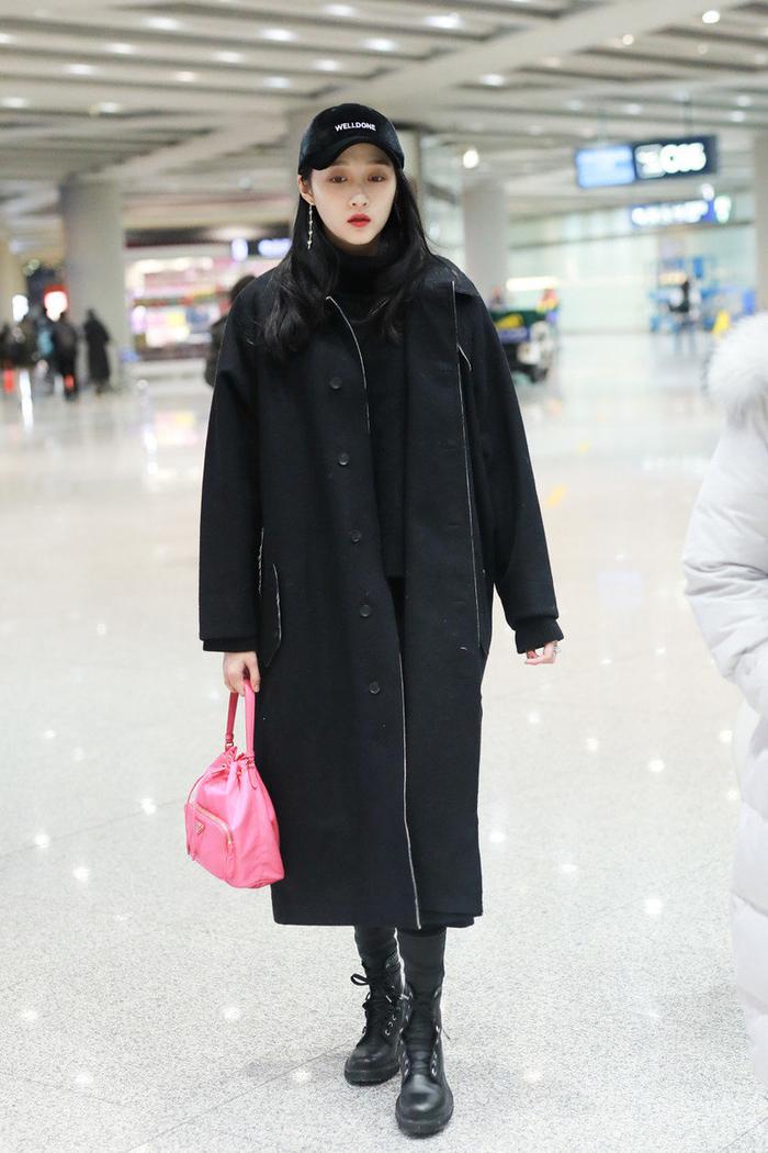 关晓彤低调走机场，黑色大衣配白手袋时尚大气，口罩覆面不敢抬头