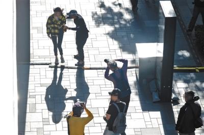 5月19日下午,三里屯太古里,男街拍爱好者拉扯经过的年轻女性要求拍摄,另两位街拍爱好者不停拍摄该女性。