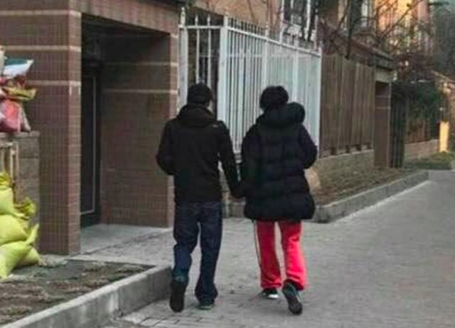 谢霆锋和王菲手牵手疑被摄影师拍到，王菲穿着红裤子