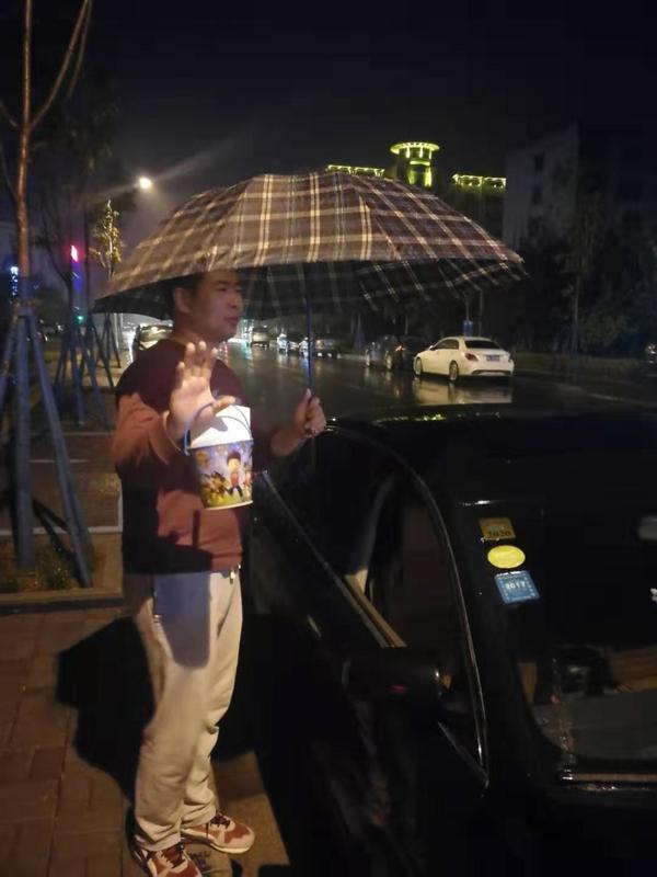 超暖!漯河男子风雨中忘关车窗，陌生人撑伞守护半小时!