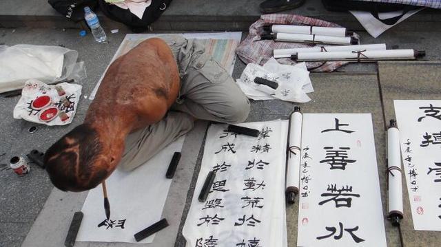 实拍：街头“无臂”书法家，用嘴书写，一幅只要80元
