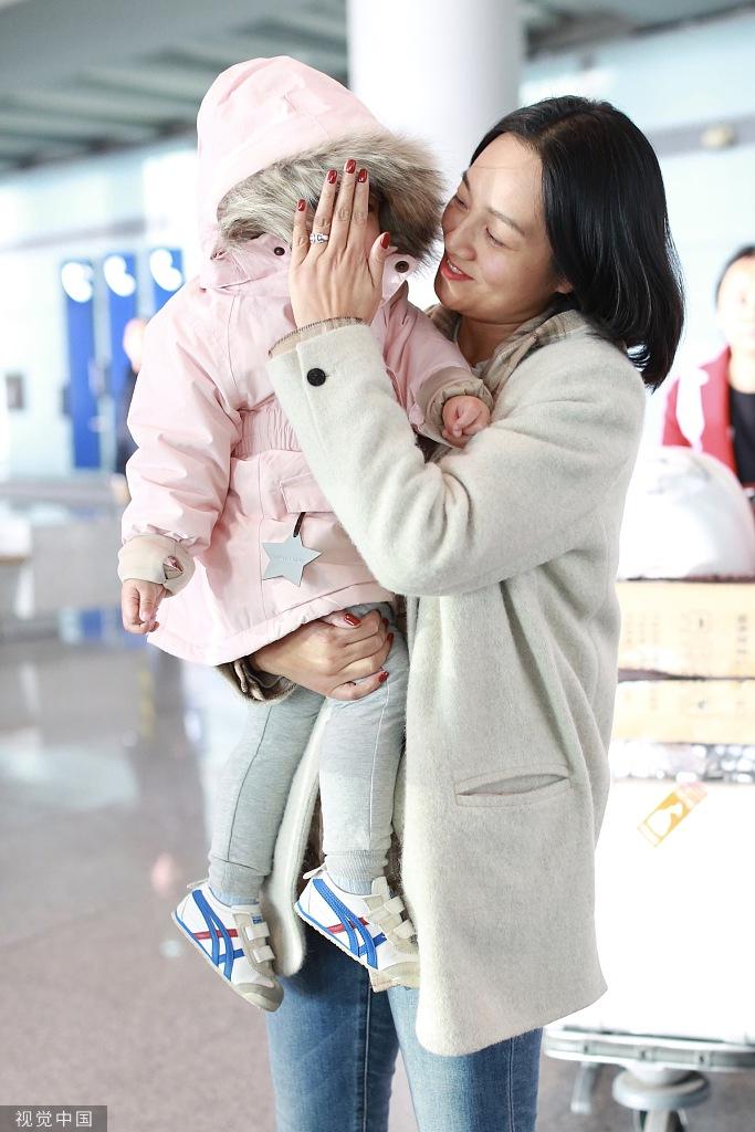 朱丹素颜现身机场抱娃大方任拍，为女儿挡风遮脸婚戒抢镜
