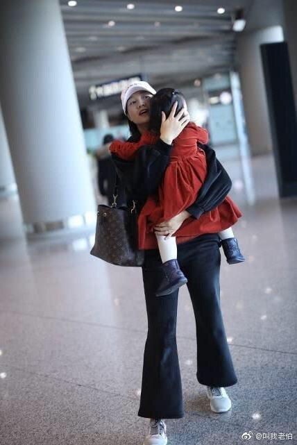 朱丹抱女儿走机场，一身宝妈装平淡的接地气，素颜照依旧美艳靓丽