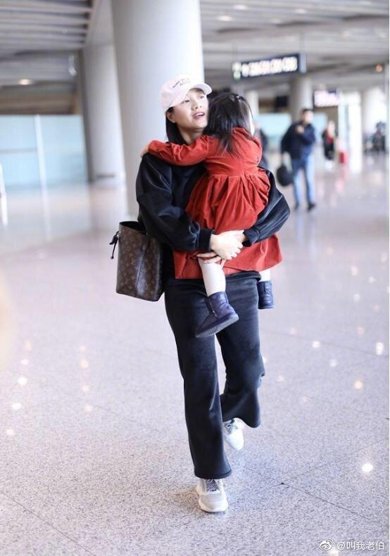 朱丹抱女儿走机场，一身宝妈装平淡的接地气，素颜照依旧美艳靓丽