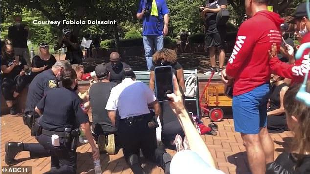 美国北卡罗来纳州白人警察跪着为黑人宗教领袖洗脚：表达谦卑与爱