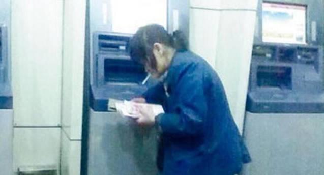 女乞丐叼着烟来提款机取钱，直接用垃圾袋装钱，真豪气！