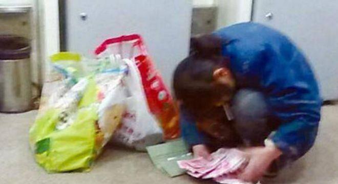 女乞丐叼着烟来提款机取钱，直接用垃圾袋装钱，真豪气！