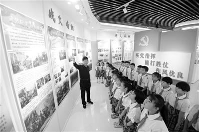 国庆前夕,河北省邯郸市四留固村小学生在该村红色电影文化博物馆强军主题文化厅,听讲解员魏少先讲述红军长征的故事。魏 行摄