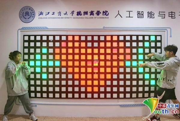 大学生在AI墙面前参与游戏互动。