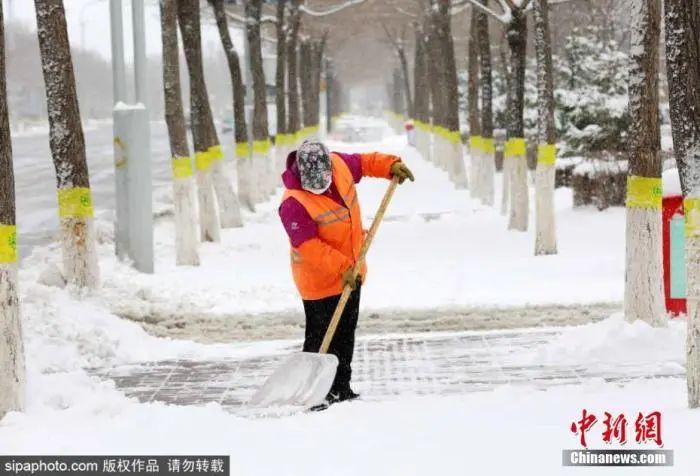 资料图：黑龙江黑河市环卫工人清扫路面积雪。图片来源：Sipaphoto