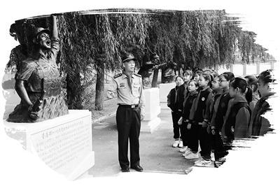 黑龙江省哈尔滨市南岗区人武部干部在英模塑像前为学生讲述英模故事。