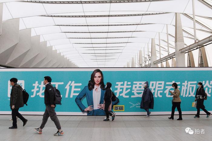 △ 3月24日,西二旗地铁站,乘客走过站内招聘广告牌。
