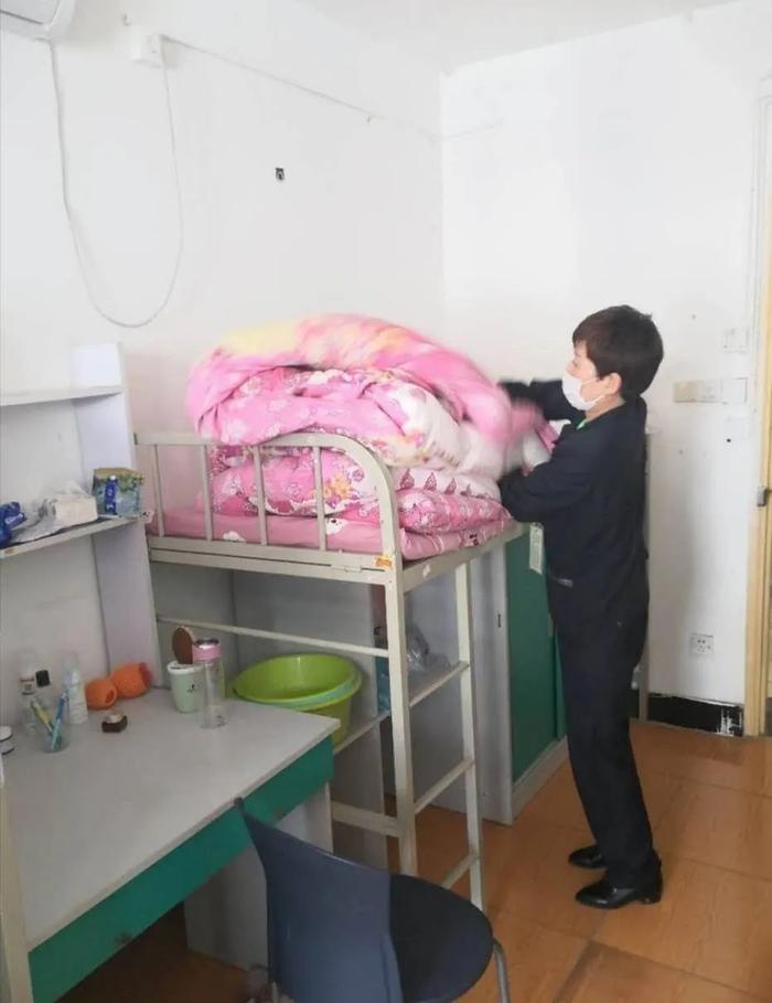 宿管员抱起被子。