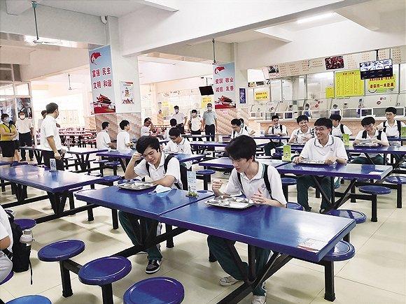 海南华侨中学开学演练:在饭堂吃饭要保持安全距离。图片来源:南国都市报