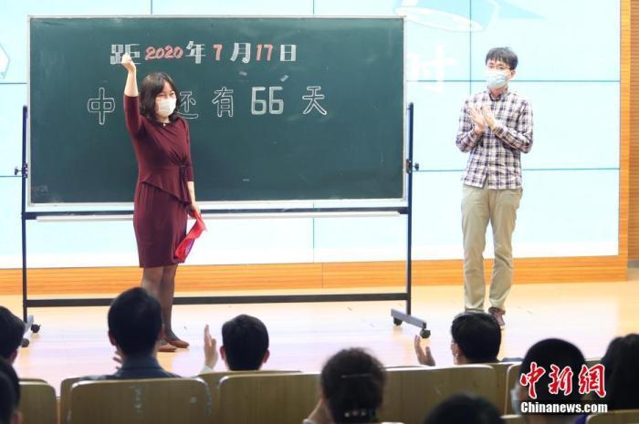 资料图:5月11日,在位于北京市西城区的北京师范大学附属实验中学内,教师代表为中考倒计时牌揭幕。当日,北京初三年级学生返校复课。 中新社记者 蒋启明 摄