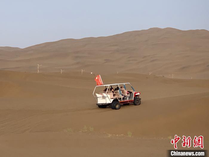 图为天航空乘人员乘车时直播沙漠冲浪。 李昱菲 摄