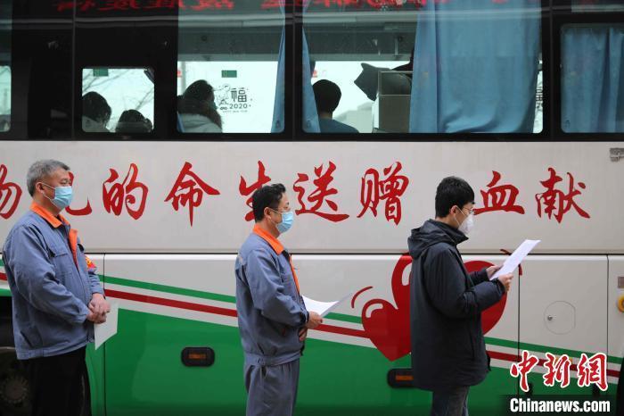 资料图:志愿者在献血车外排队等候。 张进刚 摄