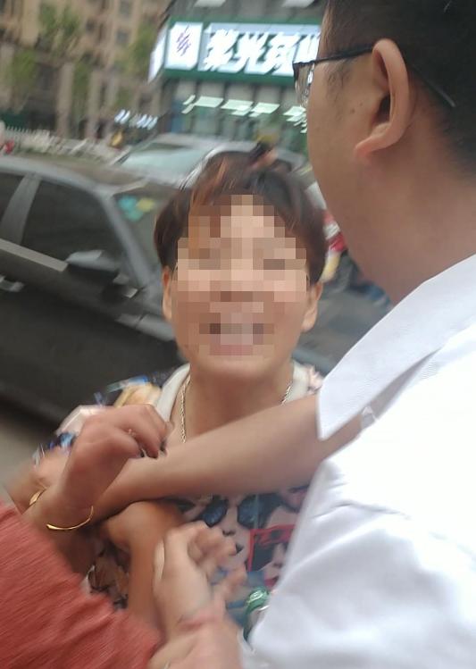 视频截图显示,田女士的丈夫在劝阻中疑似触及她的受伤部位(左侧棕红色短袖衬衣手臂为田女士丈夫手臂)