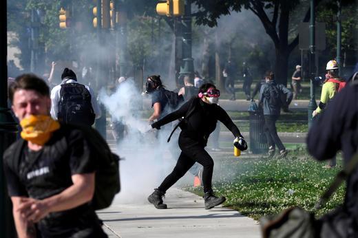 A protester returns a tear gas canister during a march in Philadelphia, June 1。 REUTERS/Bastiaan Slabbers