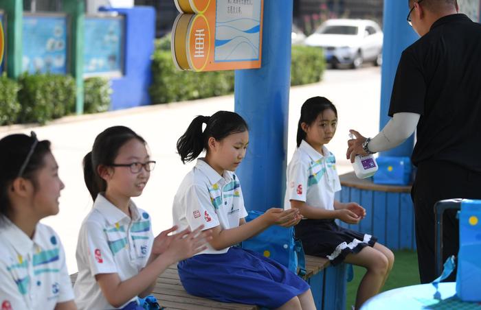 6月8日,丰台五小,四五年级返校复课,课间教师为同学进行手部消毒。