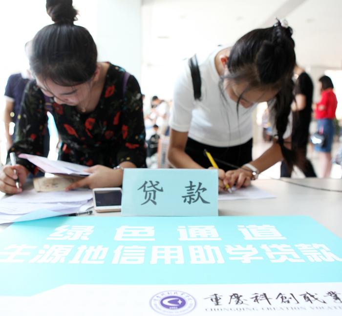 高等教育中的不公平可以通过助学贷款制度的完善在一定程度上得以修正。图为2017年8月28日,在重庆科创职业学院新生报名大厅,经济困难学生在办理助学贷款。 人民视觉 资料图